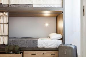 a bedroom with a bunk bed and a suitcase at Winederful Hostel & Café in Logroño