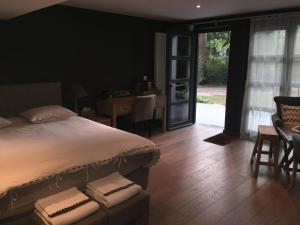 een slaapkamer met een bed en een tafel en stoelen bij B&B Des Heures Claires in Lasne