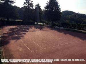 a tennis court with a net on it at Maison des Roses - Family Farm in Bossolasco