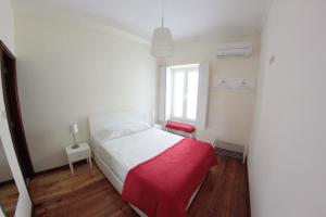 um quarto com uma cama com um cobertor vermelho em Huga Home em Lamego