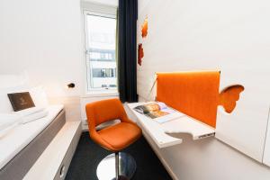 an office with an orange chair and a desk at Smarthotel Oslo in Oslo