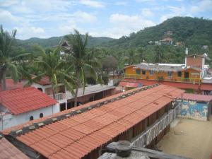 a group of buildings with palm trees and houses at Posada Brisa Marina in Zipolite