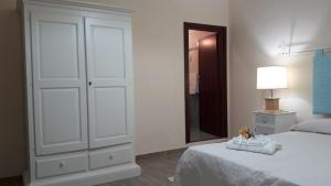 ポルト・トッレスにあるCamere Vacanze Acqua Chiaraの白いベッドルーム(ベッド1台、鏡付)