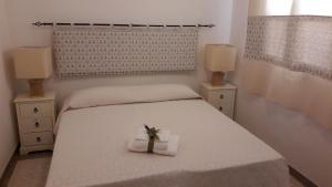 ポルト・トッレスにあるCamere Vacanze Acqua Chiaraのベッドルーム1室(ベッド1台、タオル2枚、クロス付)