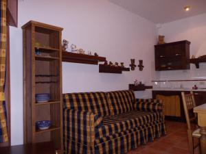 a living room with a checkered couch and a kitchen at Casa Dell'Orso in Roccaraso