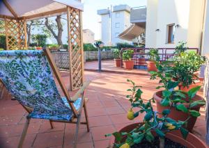 フォッローニカにあるDomus Socolatae Apartments&Suitesの鉢植えの植物が並ぶパティオ(椅子付)