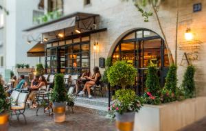 people sitting at tables outside of a restaurant at A23 Boutique Hotel in Tel Aviv