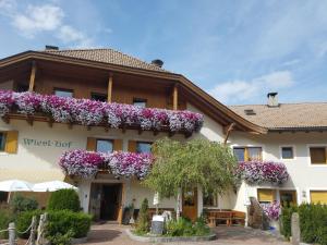 un edificio con flores a un lado. en Hotel Wieslhof, en Collepietra