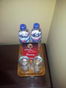 two bottles of water sitting on a wooden tray at Ndalem Suratin Guesthouse in Yogyakarta
