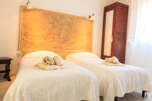 フォッローニカにあるDomus Socolatae Apartments&Suitesのベッド2台(タオル付)が備わる客室です。