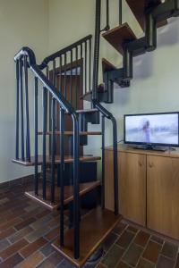 uma escada com grades pretas num quarto com televisão em Antico Casale Le Fossate em Giove