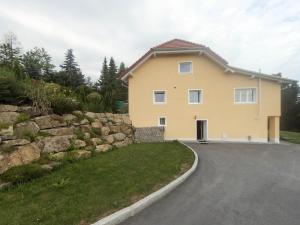 ein großes gelbes Haus mit einer Steinmauer in der Unterkunft Ferienwohnung im bayerischen Wald in Tittling