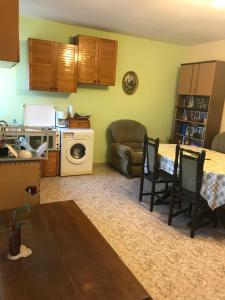 a kitchen and living room with a table and a microwave at Guesthouse Planinsko Gnezdo in Tŭzha