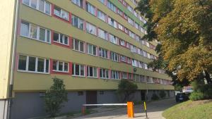 un bâtiment jaune avec des fenêtres rouges sur une rue dans l'établissement Sand Apartment, à Wrocław