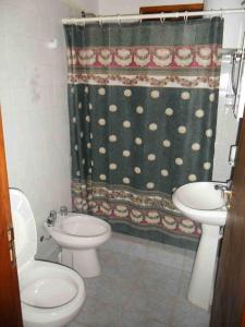 uma casa de banho com um WC, um lavatório e uma cortina de chuveiro em Killa Yurak em La Paloma