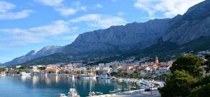 a town on a lake with mountains in the background at Dreams in Makarska