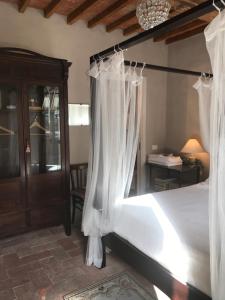 um quarto com uma cama com cortinas brancas em BBBagni em Bagni San Filippo