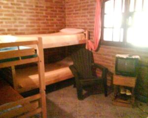 a small room with a bunk bed and a chair at Angeluz Paso De La Patria in Paso de la Patria