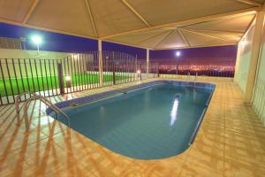 a large swimming pool in a building at night at Star City Chalets in Az Zulfi