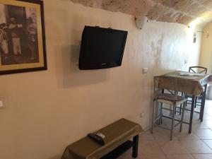 a tv on a wall with a table and a stool at Sea Home 1 in Monopoli