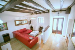 ein Wohnzimmer mit einem roten Sofa und einem Tisch in der Unterkunft Stella del Mare Apartment - Dubrovnik Old Town Getaway in Dubrovnik