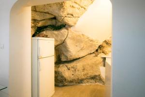 einen weißen Kühlschrank vor einer Felswand in der Unterkunft Stella del Mare Apartment - Dubrovnik Old Town Getaway in Dubrovnik