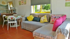a living room with a couch with colorful pillows at Avermar in Ericeira