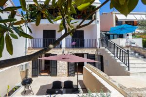 a patio with a pink umbrella and chairs and stairs at Monte & Paradiso in Pula