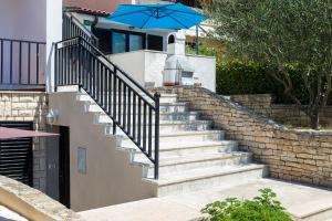 a staircase with a blue umbrella on top of it at Monte & Paradiso in Pula