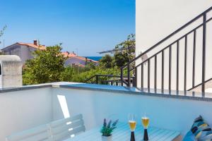 a swimming pool with two wine glasses on a balcony at Monte & Paradiso in Pula