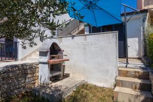 a stone wall and stairs with a blue umbrella at Monte & Paradiso in Pula
