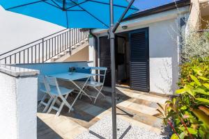 a blue table and chairs on a patio with an umbrella at Monte & Paradiso in Pula