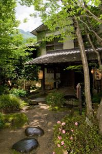 a garden with rocks in front of a house at Hotaru no Yado Sendou in Yufu