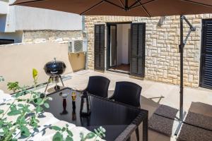 a table with chairs and an umbrella on a patio at Monte & Paradiso in Pula