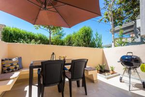 a patio with a table and chairs and an umbrella at Monte & Paradiso in Pula