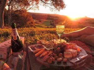 a picnic with a plate of food and a bottle of wine at Eumundi Mountain Retreat in Eumundi +22 photos