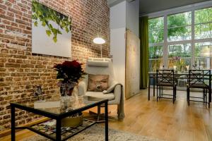 a living room with a brick wall and a table at BXLROOM Guesthouse in Brussels