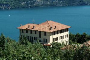 ein Haus auf einem Hügel neben dem Wasser in der Unterkunft Hotel Brisino in Stresa