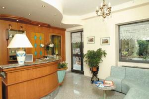 a lobby with a reception desk and a blue couch at Hotel Brisino in Stresa