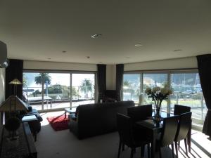 a living room with a couch and a table with chairs at Luxury Waterfront Apartment - Quay No 6 in Picton