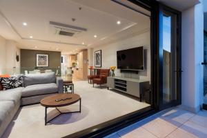 - un salon avec un canapé et une télévision dans l'établissement Ocean Eleven 5, à Mount Maunganui