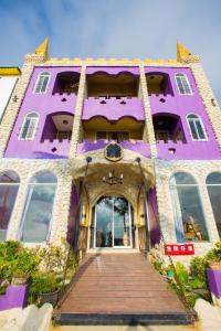 鵝鑾的住宿－墾丁戀戀莎堡特色民宿 Castillo，一座紫色的建筑,前面设有木制走道