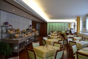 a restaurant with tables and chairs in a room at Hotel Due Leoni in Sacile