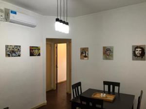 a dining room with a table and chairs and pictures on the wall at Departamento La Plata in La Plata