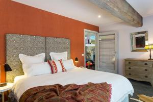 a bedroom with a large white bed with orange walls at Planetrees Estate in Beechworth