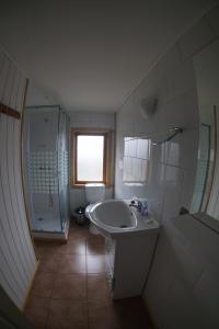 ein weißes Bad mit einem Waschbecken und einer Dusche in der Unterkunft Hostería Futaleufu in Futaleufú