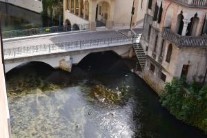 einen Blick über eine Brücke über den Fluss in der Unterkunft Hotel Due Leoni in Sacile