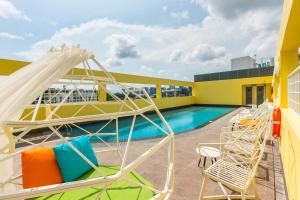 a balcony with chairs and a pool on a building at ibis budget Singapore Selegie in Singapore