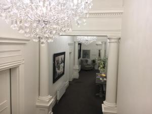 a hallway with white columns and a chandelier at Ballarat Premier Apartments in Ballarat