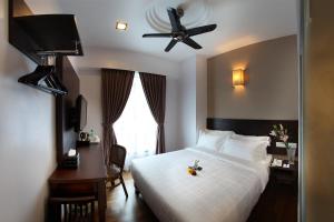 1 dormitorio con cama blanca y ventilador de techo en Hotel Richbaliz Selayang en Batu Caves